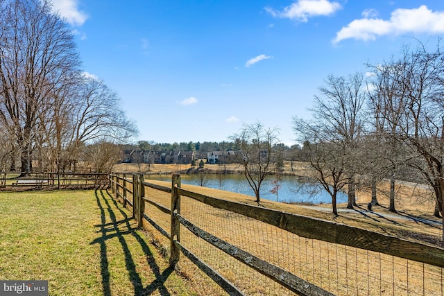 view of yard with a water view, fence, and a rural view