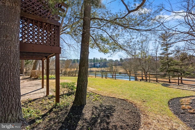 view of yard featuring a water view and fence