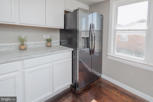 kitchen featuring stainless steel fridge, baseboards, dark wood finished floors, light countertops, and white cabinetry