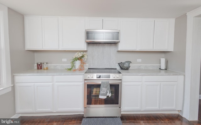 kitchen featuring electric stove, exhaust hood, light countertops, and white cabinets