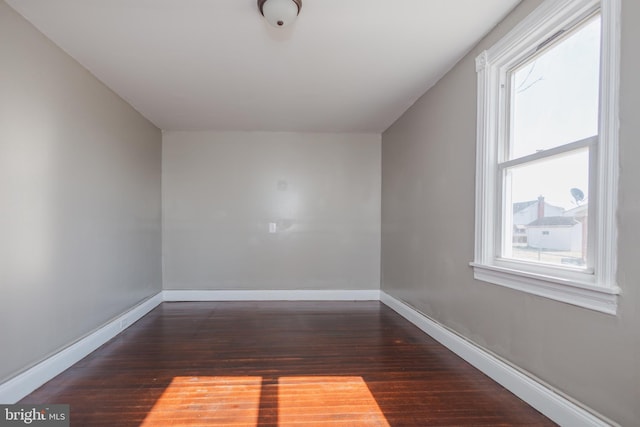 additional living space with wood finished floors and baseboards