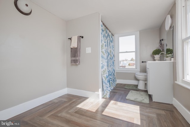 full bath with curtained shower, baseboards, vanity, and toilet