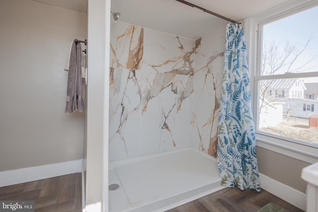 full bath featuring a shower stall and baseboards