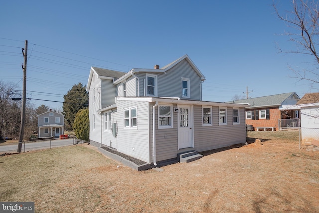 exterior space featuring entry steps, fence, and a lawn