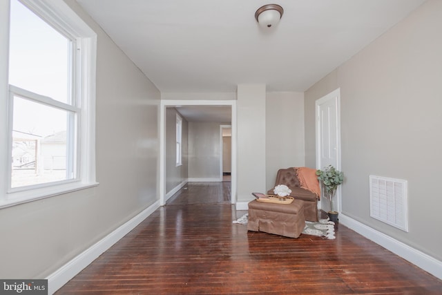 sitting room with visible vents, baseboards, and wood finished floors