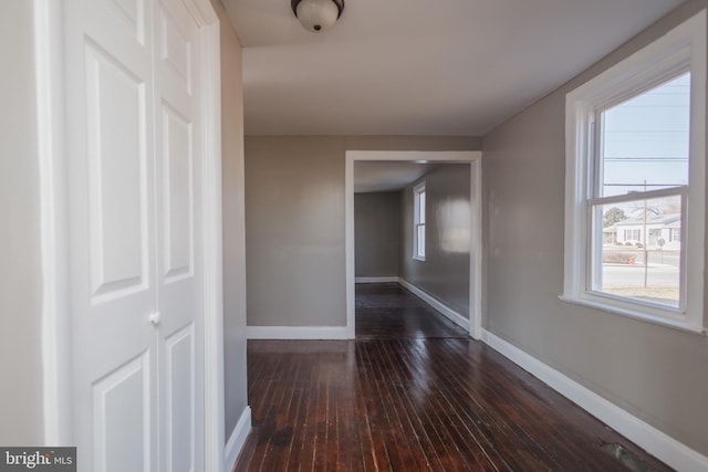 hallway with dark wood-style floors and baseboards