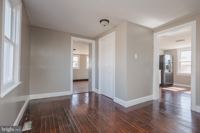 spare room featuring wood-type flooring and baseboards