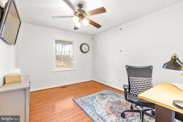 home office featuring visible vents, ceiling fan, baseboards, and wood finished floors