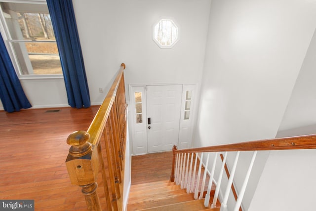 stairway with visible vents, baseboards, and wood finished floors