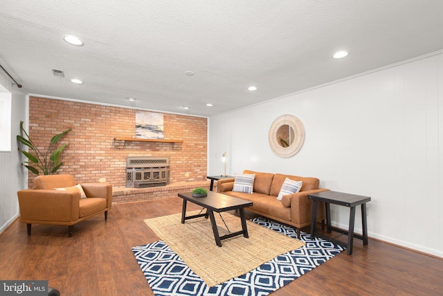 living room with a textured ceiling, recessed lighting, wood finished floors, visible vents, and crown molding