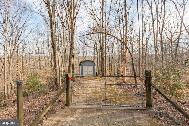 view of gate featuring an outdoor structure and a storage shed