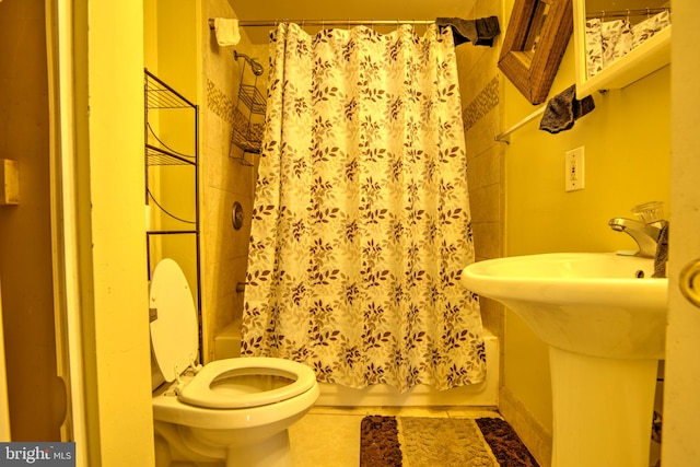 full bathroom with shower / bath combination with curtain, a sink, toilet, and tile patterned floors