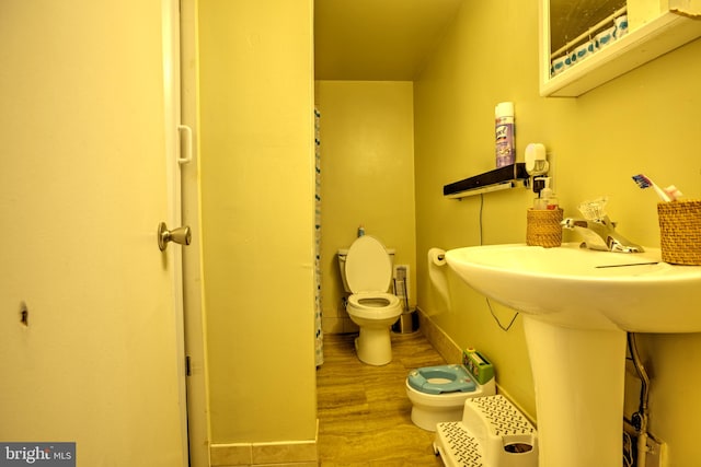 bathroom with toilet and wood finished floors