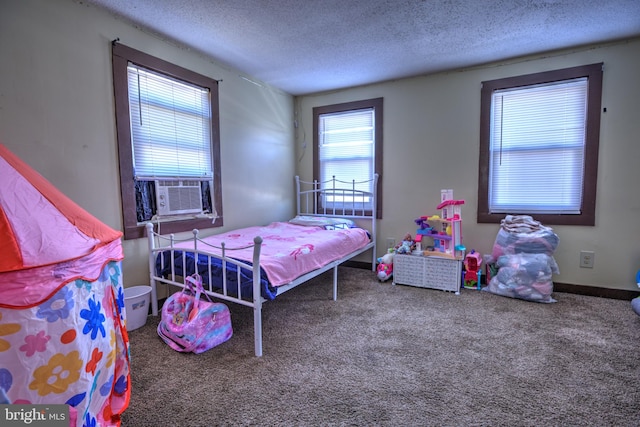 bedroom with carpet, a textured ceiling, baseboards, and cooling unit