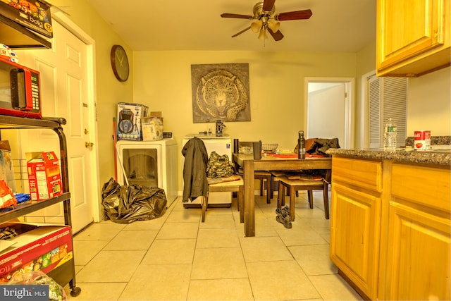 dining area with light tile patterned floors, ceiling fan, and washer and clothes dryer