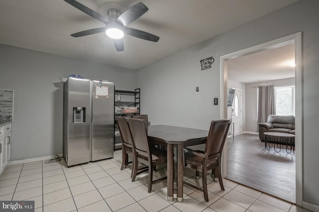 dining area featuring light tile patterned floors, ceiling fan, and baseboards