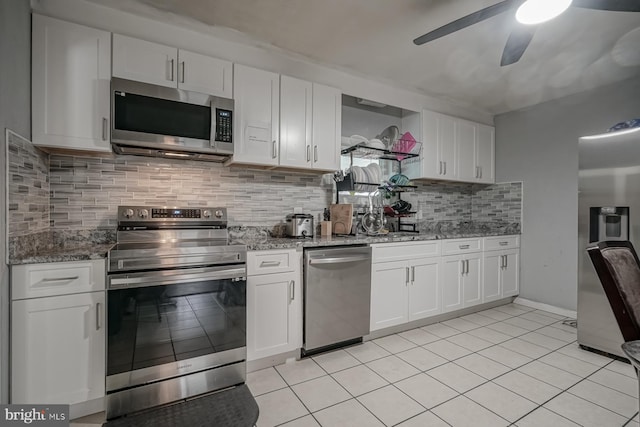 kitchen with decorative backsplash, appliances with stainless steel finishes, light stone counters, white cabinetry, and light tile patterned flooring