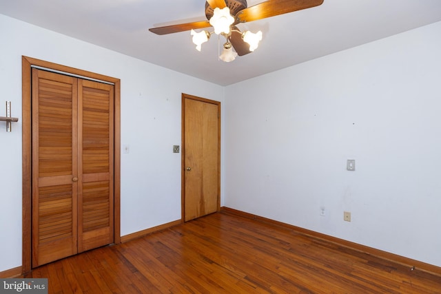 unfurnished bedroom with wood-type flooring, baseboards, ceiling fan, and a closet