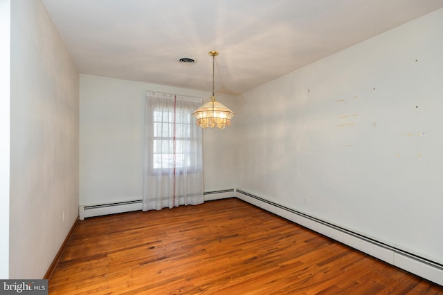 unfurnished room featuring a chandelier, hardwood / wood-style floors, baseboard heating, and visible vents