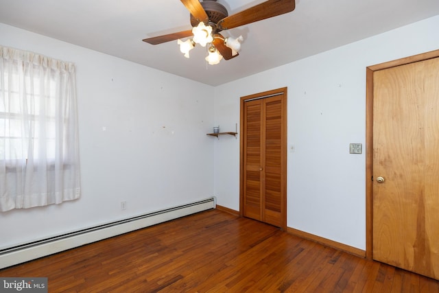 unfurnished bedroom with a ceiling fan, baseboards, baseboard heating, and hardwood / wood-style floors