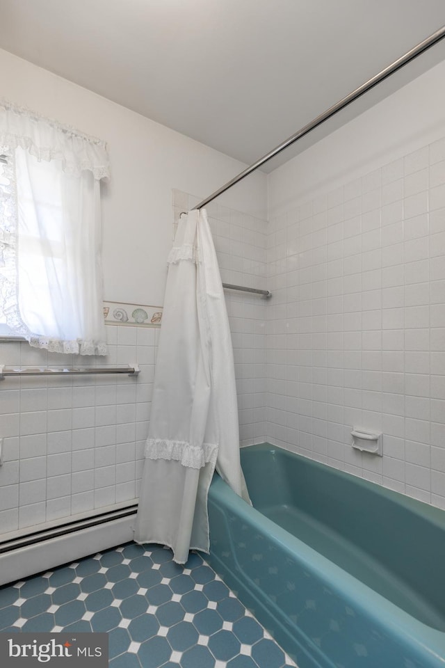 bathroom with shower / tub combo, a wainscoted wall, tile walls, and tile patterned floors