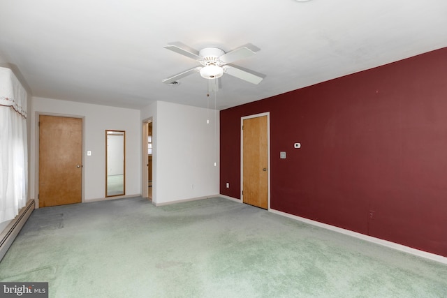 unfurnished room featuring a baseboard heating unit, carpet, ceiling fan, and baseboards