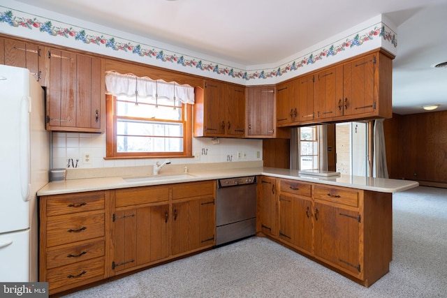 kitchen with a sink, brown cabinetry, and dishwasher