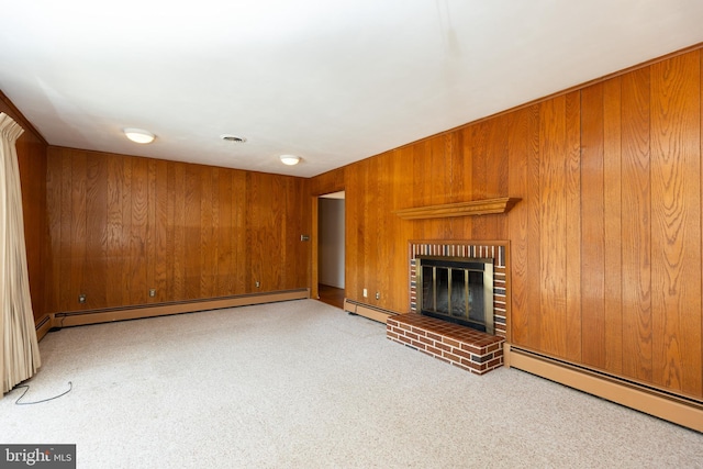 unfurnished living room featuring baseboard heating, a brick fireplace, visible vents, and wooden walls