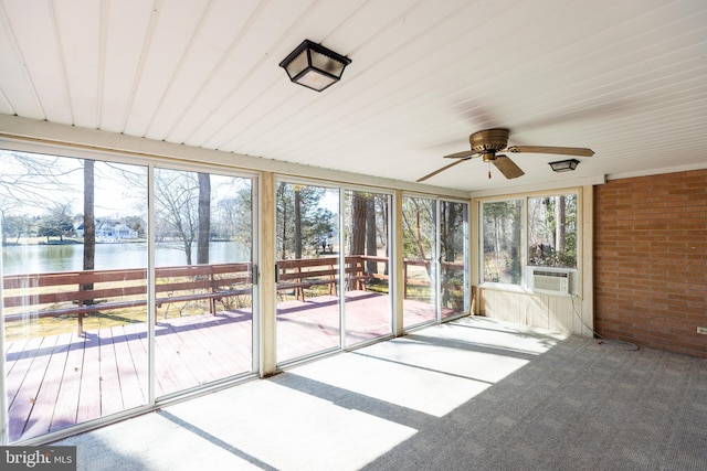 unfurnished sunroom with a water view, a ceiling fan, and cooling unit