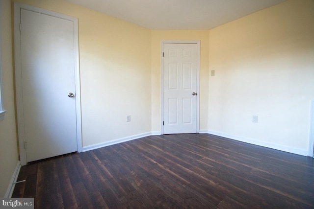 unfurnished bedroom with dark wood finished floors and baseboards