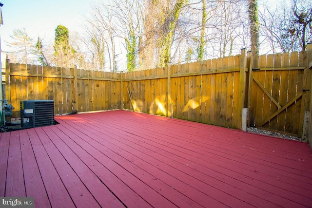 wooden deck featuring a gate, fence, and cooling unit