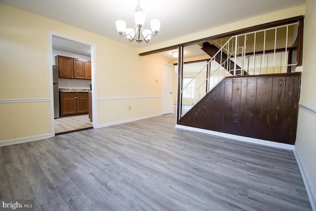 interior space with a notable chandelier, stairway, baseboards, and wood finished floors