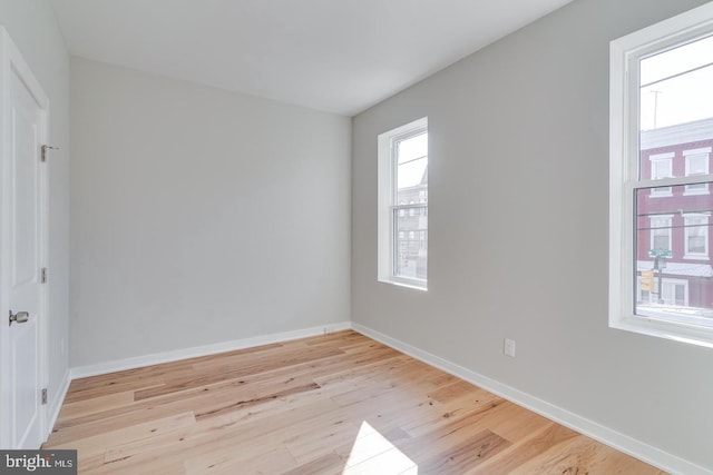 unfurnished room with baseboards and light wood finished floors