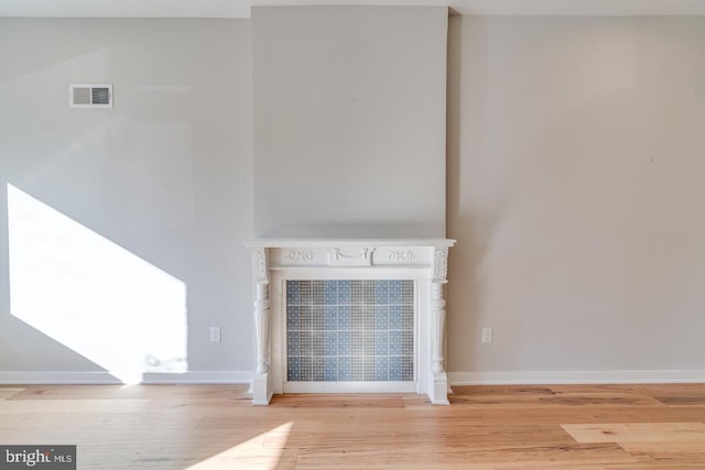 interior space with visible vents, baseboards, and wood finished floors