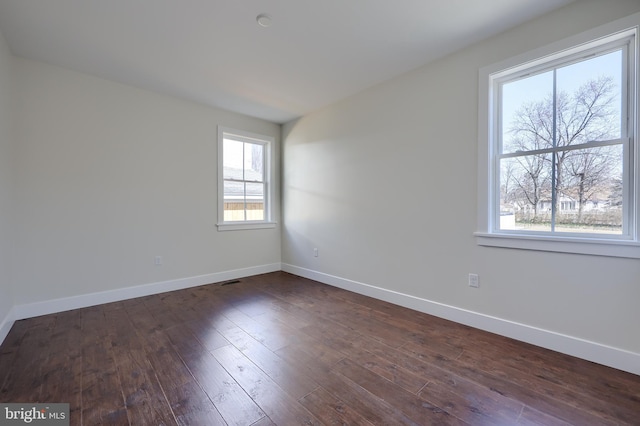 unfurnished room featuring dark wood-style floors and baseboards