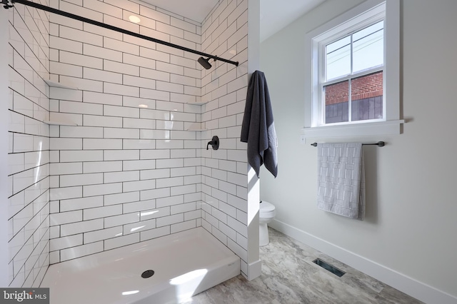 bathroom featuring toilet, a shower stall, visible vents, and baseboards