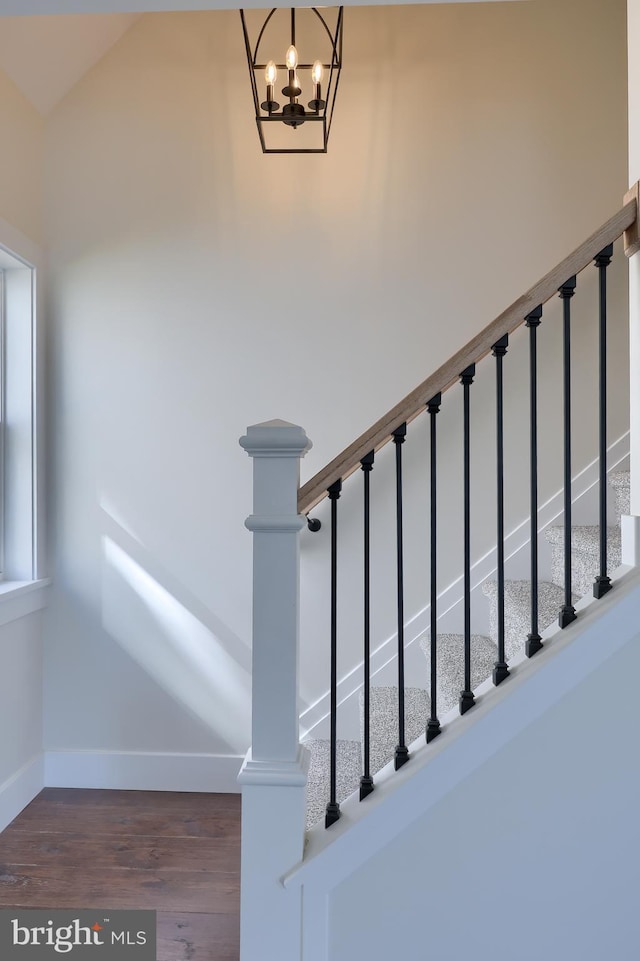 staircase with baseboards and wood finished floors