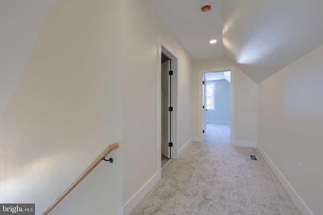 hall featuring recessed lighting, baseboards, vaulted ceiling, and light colored carpet