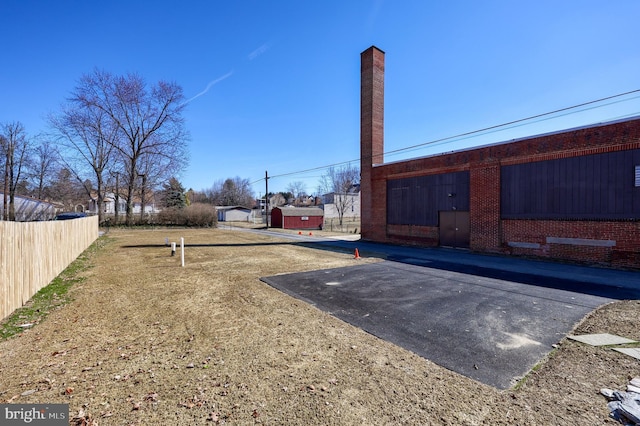 view of yard featuring driveway and fence