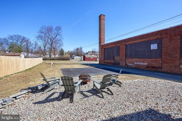 view of yard with an outdoor fire pit and fence