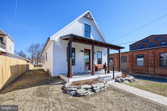 view of front of home featuring fence, a porch, and board and batten siding