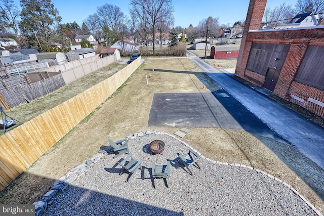 exterior space featuring an outdoor fire pit, a residential view, and fence