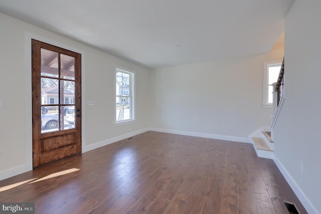 entrance foyer featuring dark wood-type flooring, stairway, and baseboards