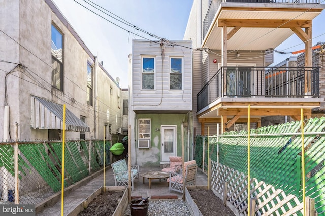 back of house with a garden, fence, and a fire pit