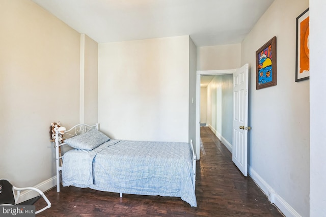 bedroom with baseboards and wood finished floors