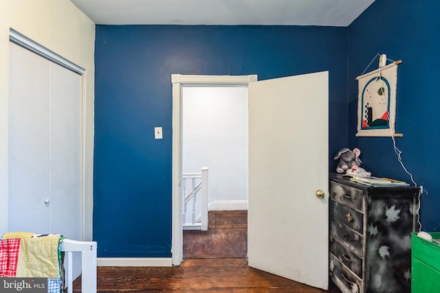 bedroom featuring a closet, wood finished floors, and baseboards