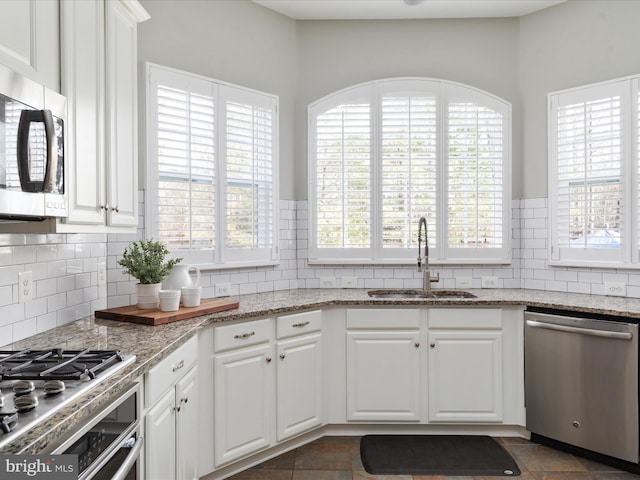 kitchen featuring a healthy amount of sunlight, white cabinetry, appliances with stainless steel finishes, and a sink