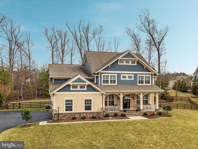 view of front of home featuring driveway, fence, a front lawn, and a porch