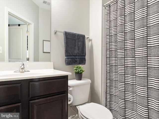 bathroom with visible vents, vanity, and toilet