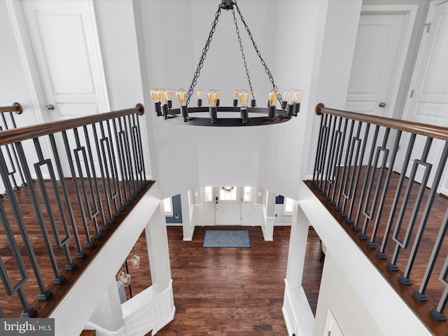 stairs with a notable chandelier, baseboards, and wood finished floors